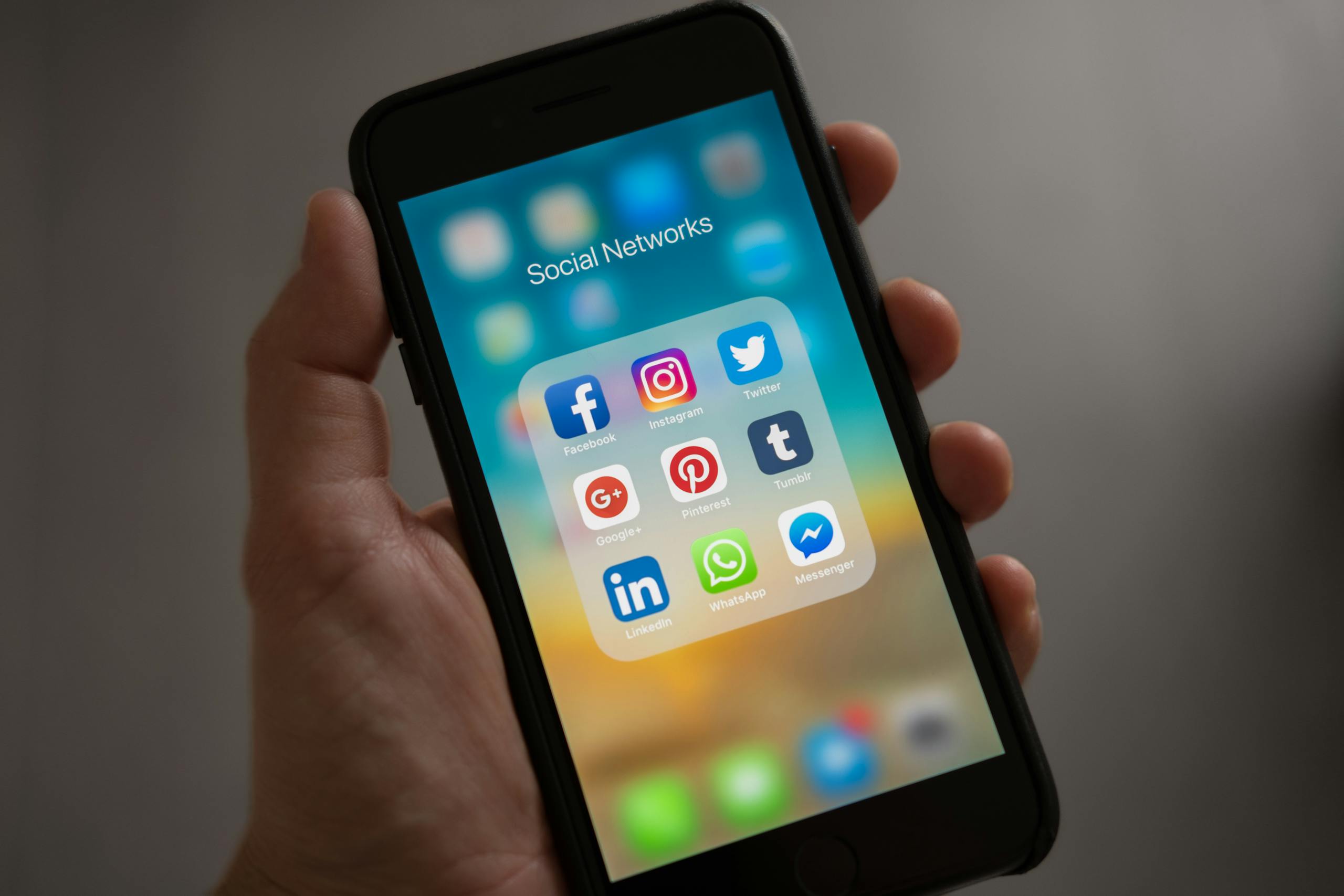 JuicyCRM JuicyCRM: Your Business Command Centre | A smartphone displaying various social media icons held in a hand, showcasing modern communication apps.