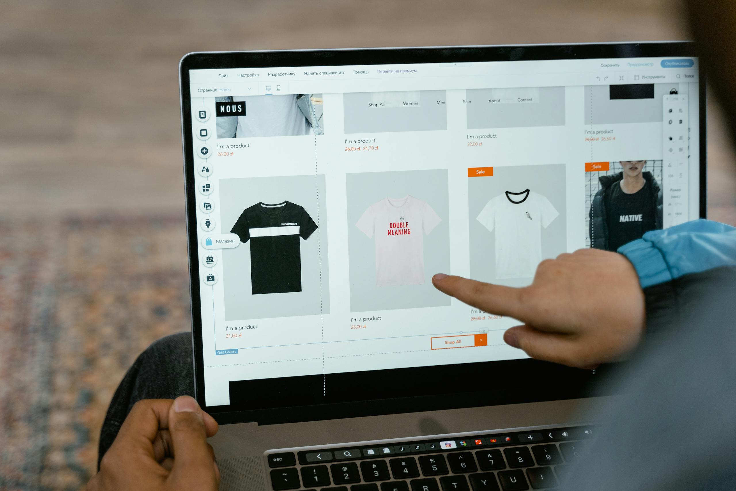 JuicyCRM A person points to t-shirt options in an online store on a laptop screen. JuicyCRM for Ecommerce Stores